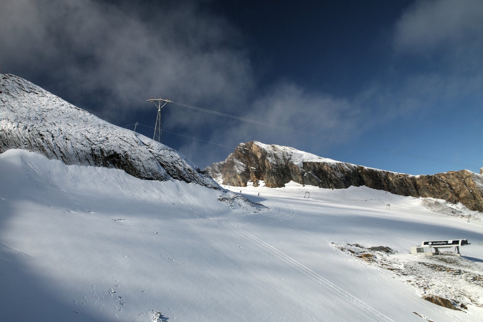A Schmiedingerbahn nyolcüléses hegyállomása, háttérben a Kitz gleccserliftek