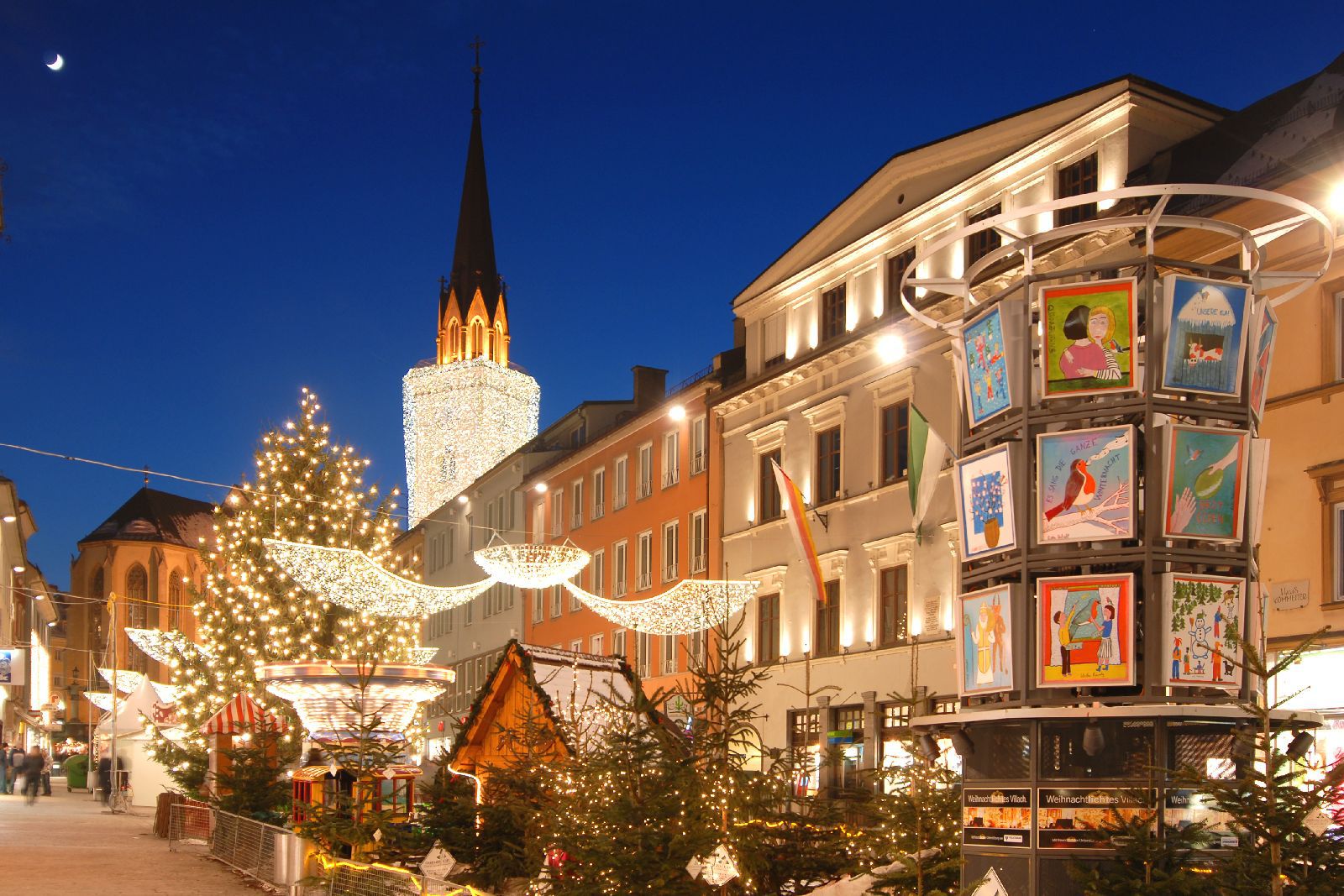 Villachban a csodásan kivilágított torony alatt - mely mint egy hatalmas gyertya ragyog a város felett - található a karácsonyi vásár.