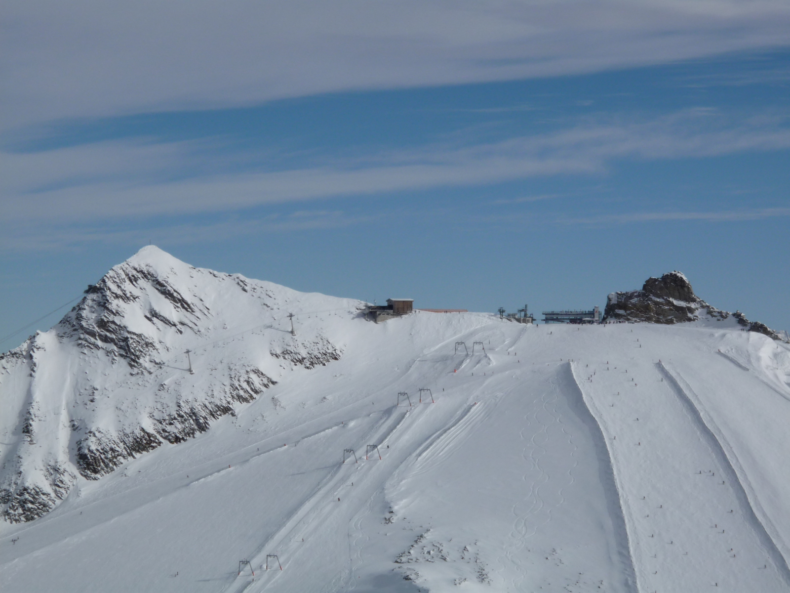 A Gefrorene Wand (3287 m) csúcsa, felvonói, pályái, kilátóterasza szemből, az Olperer lábától