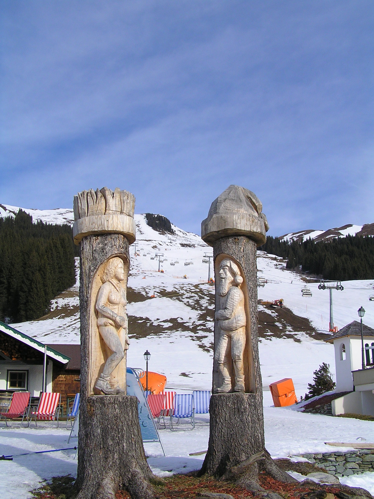 Fenyőtörzsbe faragott szobrok a Sonnhof-nál